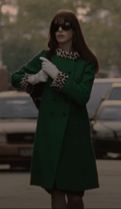 A confident stride through the city streets, Andy Sachs commands attention in a vibrant emerald green coat, its classic silhouette playfully accented with a chic leopard print collar and cuffs, perfectly paired with crisp white gloves.